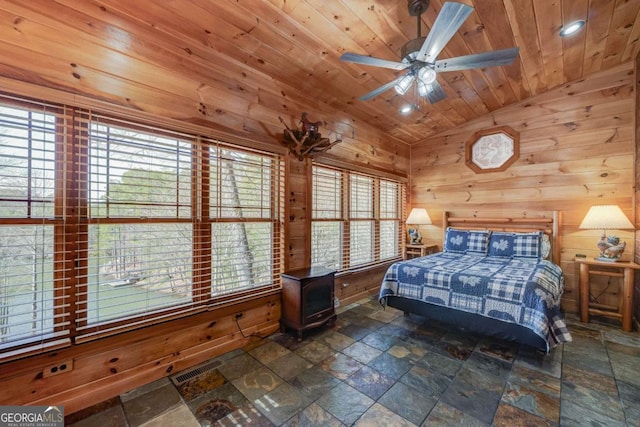 bedroom featuring stone tile flooring, visible vents, vaulted ceiling, wood walls, and wooden ceiling