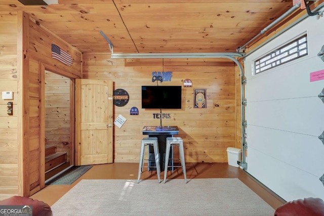 interior space with a garage, wooden ceiling, and wooden walls