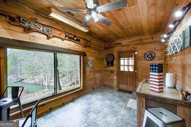 office area featuring wood ceiling, a water view, wood walls, and visible vents