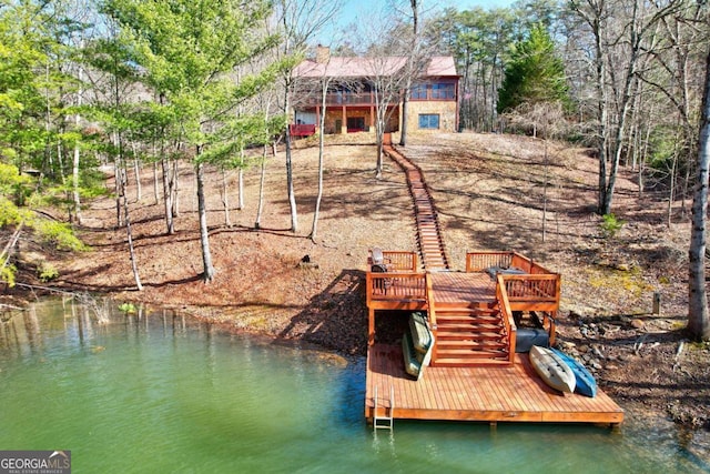 dock area featuring a deck with water view and stairs