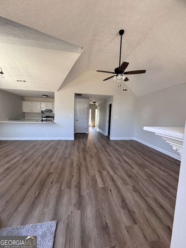 unfurnished living room featuring lofted ceiling, visible vents, and dark wood finished floors