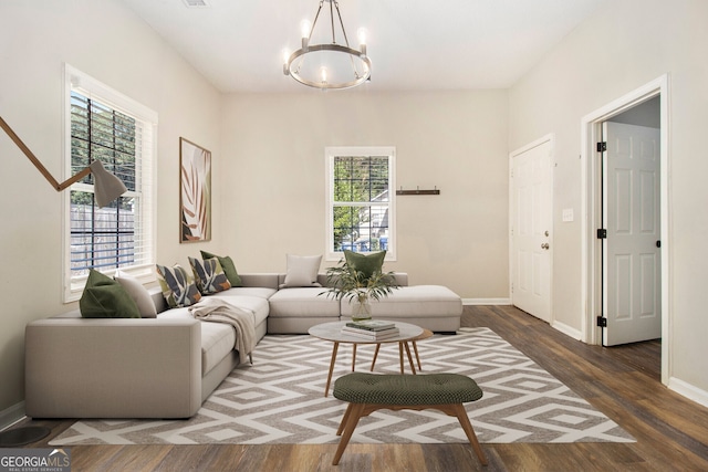 living area with an inviting chandelier, baseboards, and wood finished floors