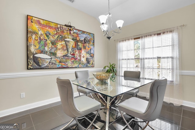 dining room featuring a chandelier, lofted ceiling, visible vents, baseboards, and tile patterned floors