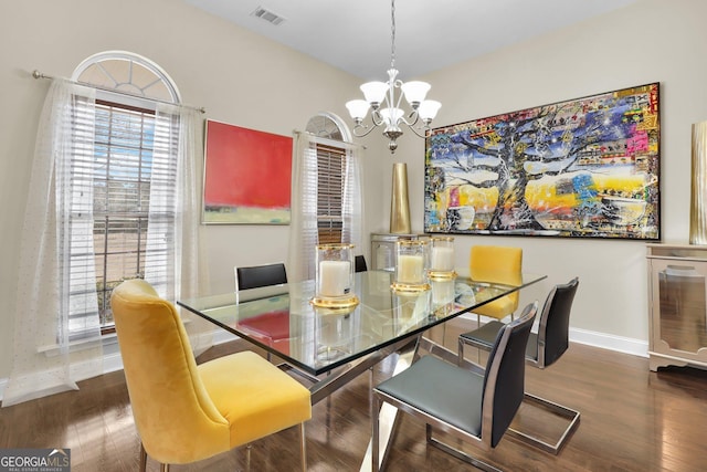 dining room featuring an inviting chandelier, baseboards, visible vents, and wood finished floors