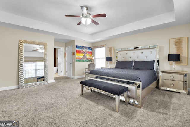 bedroom with carpet floors, a tray ceiling, a ceiling fan, and baseboards