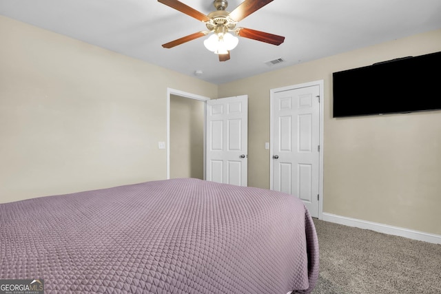 unfurnished bedroom featuring carpet flooring, ceiling fan, visible vents, and baseboards