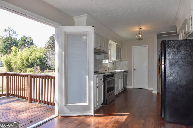 kitchen featuring dark wood-style flooring, stainless steel appliances, white cabinetry, a sink, and under cabinet range hood