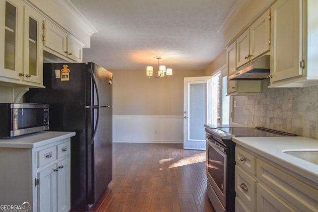 kitchen featuring a wainscoted wall, light countertops, appliances with stainless steel finishes, dark wood-type flooring, and under cabinet range hood