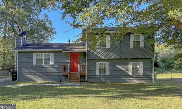 tri-level home featuring crawl space, a chimney, fence, and a front yard