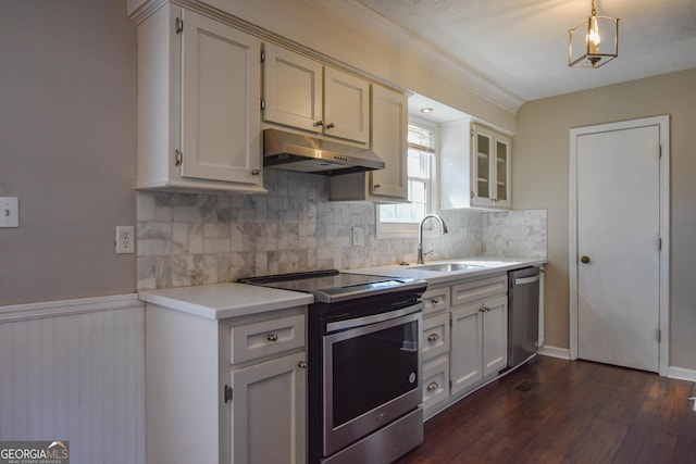 kitchen with under cabinet range hood, stainless steel appliances, a sink, light countertops, and dark wood finished floors