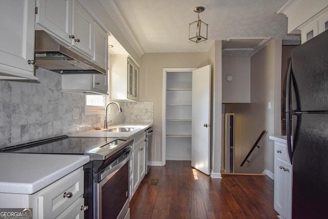 kitchen featuring white cabinets, dark wood-style flooring, stainless steel appliances, under cabinet range hood, and a sink