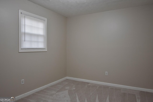 unfurnished room with light carpet, a textured ceiling, and baseboards