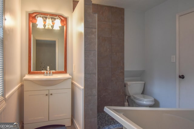 full bath with a wainscoted wall, vanity, toilet, and tiled shower