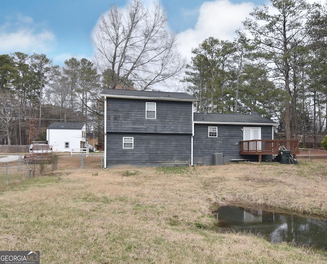 back of property featuring a yard, fence, a wooden deck, and central air condition unit