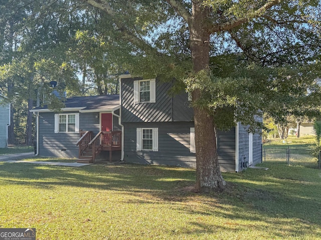 split level home featuring a front yard and fence