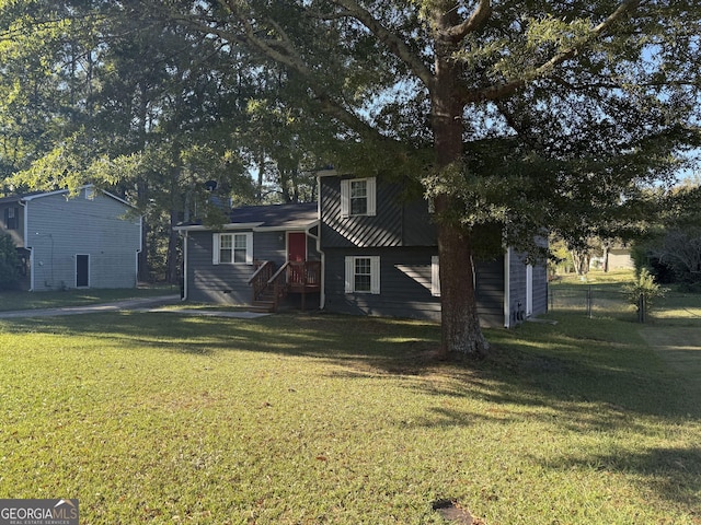 tri-level home featuring a front yard and fence