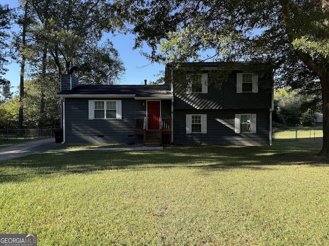 tri-level home with crawl space, a chimney, fence, and a front yard