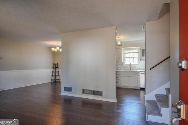 interior space with visible vents, dark wood-style flooring, a sink, and wainscoting