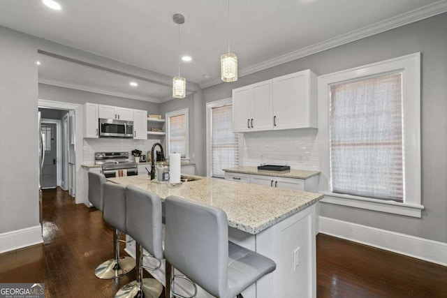 kitchen featuring appliances with stainless steel finishes, dark wood-style flooring, light stone counters, and white cabinets