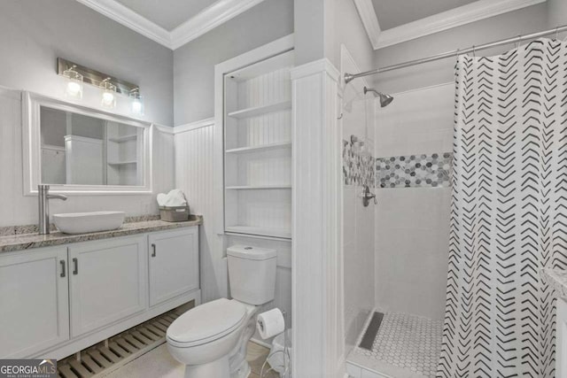 bathroom featuring vanity, ornamental molding, a tile shower, and toilet