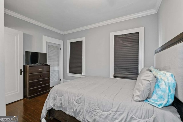 bedroom featuring ornamental molding and wood finished floors