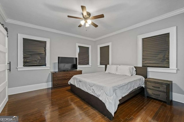 bedroom with crown molding, a barn door, wood finished floors, and baseboards