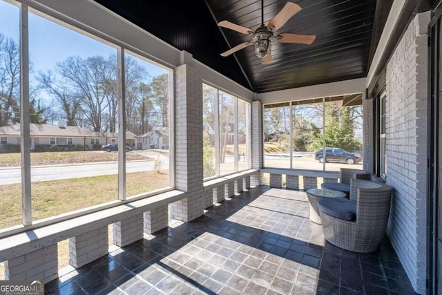 sunroom featuring vaulted ceiling, wooden ceiling, and a ceiling fan