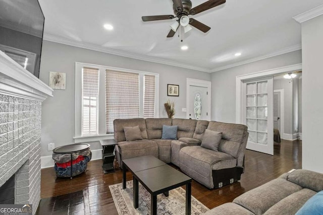 living room with recessed lighting, baseboards, a brick fireplace, hardwood / wood-style floors, and crown molding