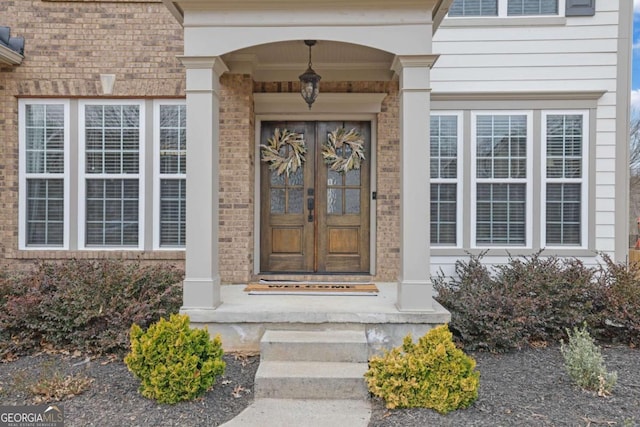 entrance to property featuring french doors and brick siding