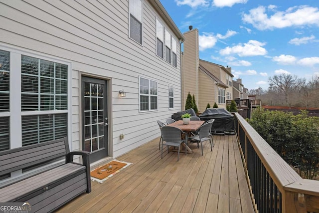 deck featuring outdoor dining area and a grill