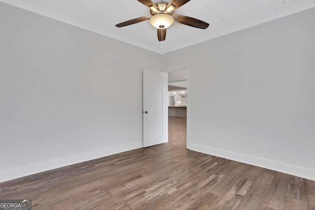 spare room featuring a ceiling fan, baseboards, and wood finished floors