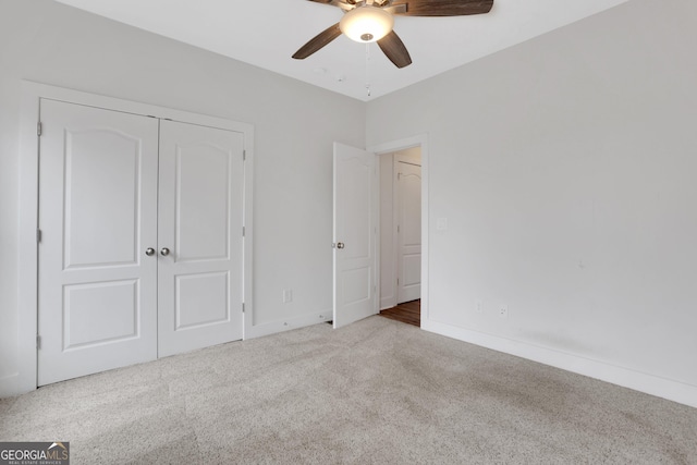 unfurnished bedroom featuring carpet floors, a closet, a ceiling fan, and baseboards