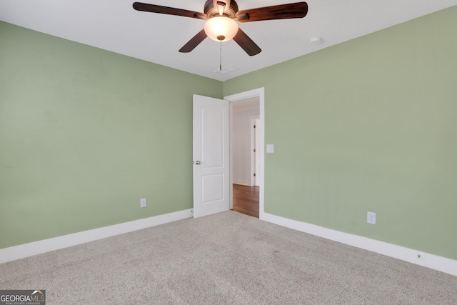 spare room featuring carpet, a ceiling fan, and baseboards