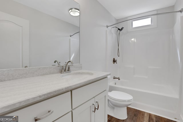 bathroom with toilet, shower / bath combination, wood finished floors, and vanity