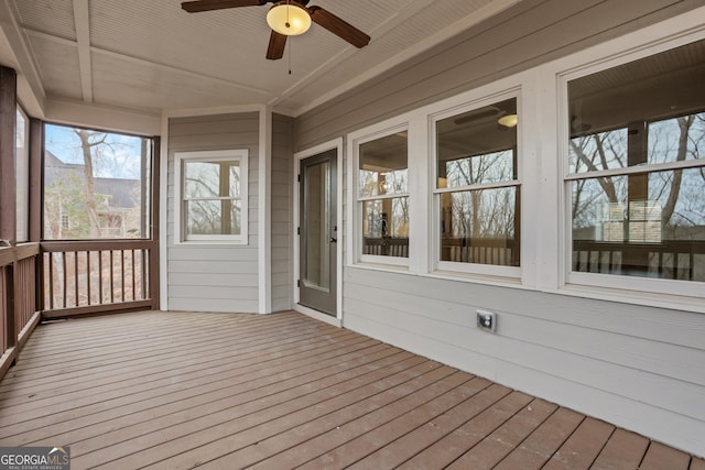 unfurnished sunroom featuring ceiling fan