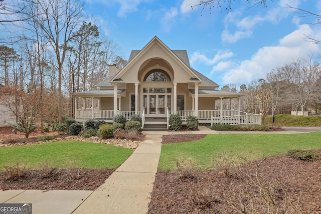 view of front of home with a chimney, covered porch, french doors, a front lawn, and stucco siding