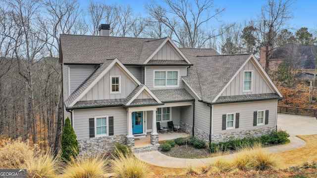 craftsman inspired home with board and batten siding, roof with shingles, and a chimney