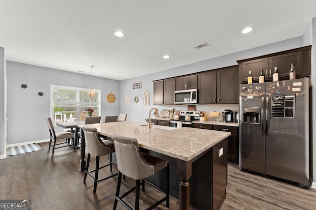 kitchen with dark wood-style floors, visible vents, appliances with stainless steel finishes, a sink, and dark brown cabinetry