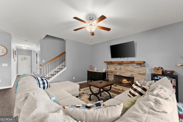 living room with stairway, a fireplace, baseboards, and wood finished floors