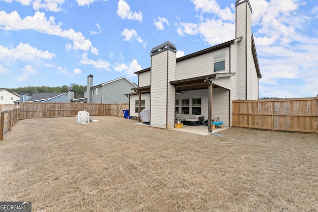 back of house featuring a patio area, a fenced backyard, a chimney, and a ceiling fan