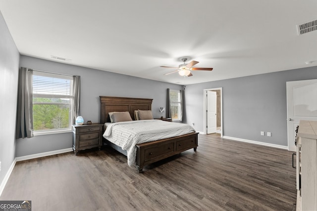 bedroom featuring dark wood-style floors, visible vents, baseboards, and a ceiling fan