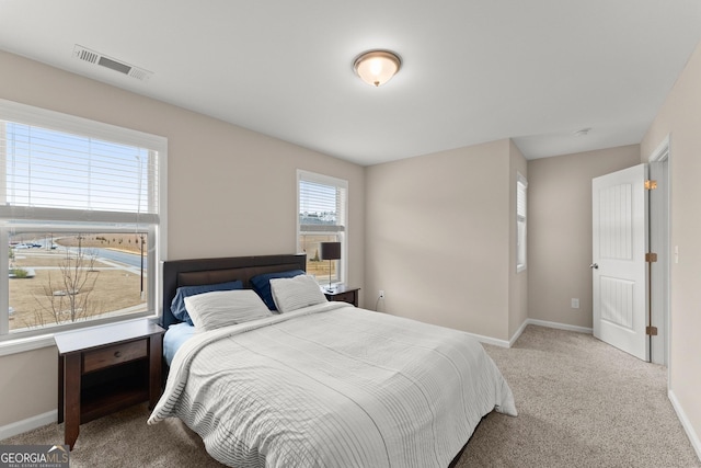 carpeted bedroom featuring baseboards and visible vents