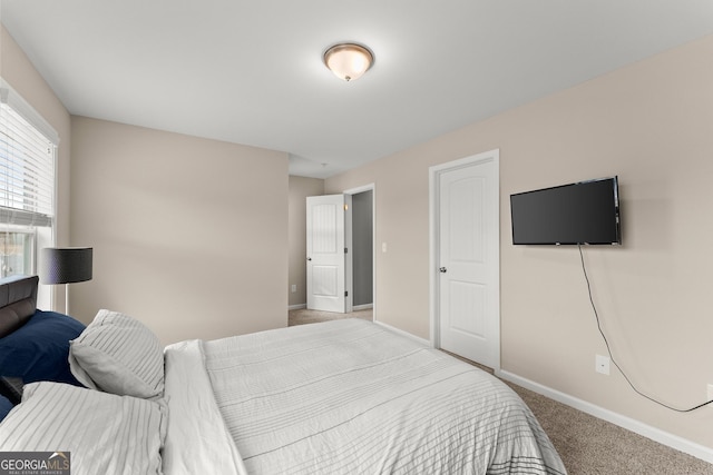 bedroom featuring light carpet and baseboards