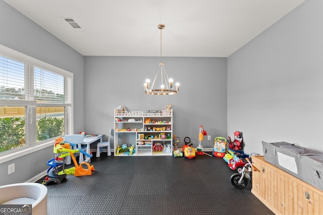 recreation room with visible vents, a notable chandelier, and baseboards