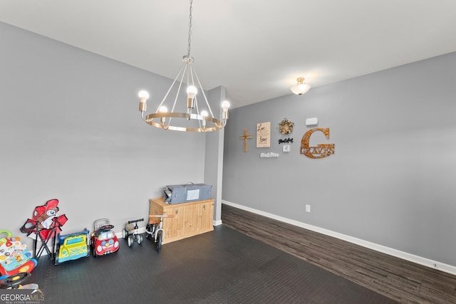 interior space featuring baseboards, a chandelier, and wood finished floors