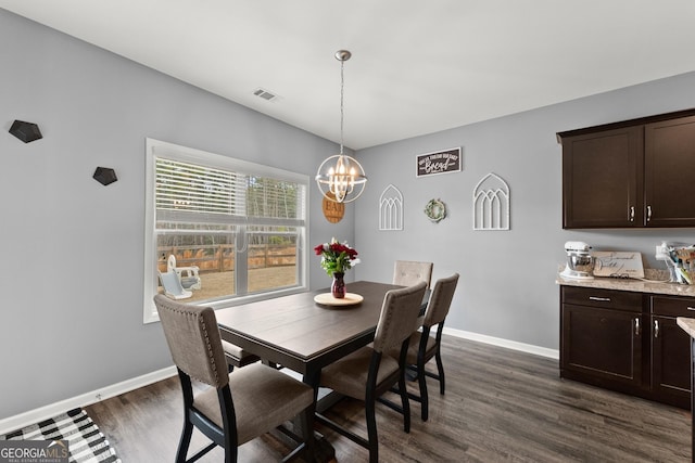 dining space with visible vents, dark wood finished floors, baseboards, and an inviting chandelier