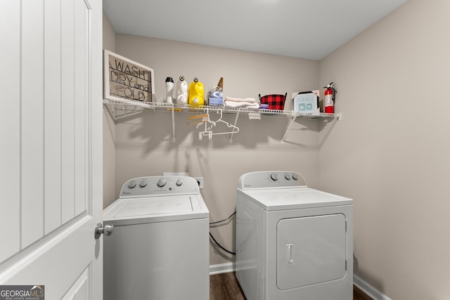 laundry room featuring baseboards, laundry area, dark wood-type flooring, and washer and dryer