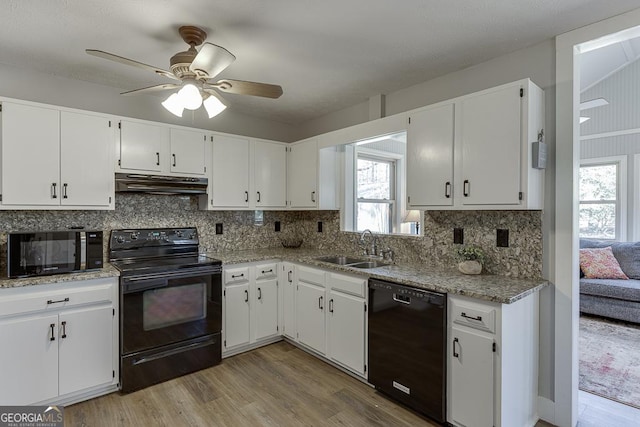 kitchen featuring decorative backsplash, under cabinet range hood, black appliances, white cabinetry, and a sink