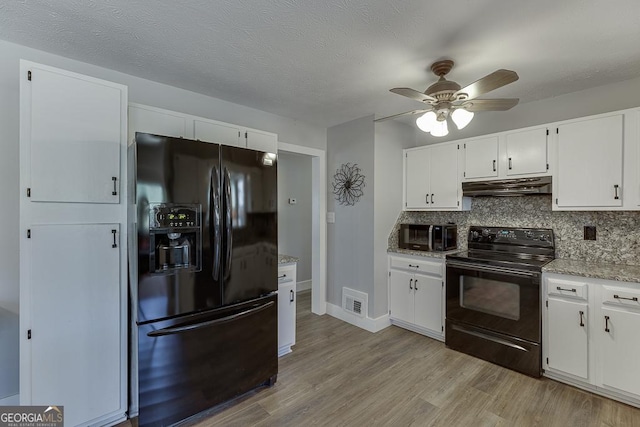 kitchen featuring decorative backsplash, light wood-style floors, under cabinet range hood, and black appliances