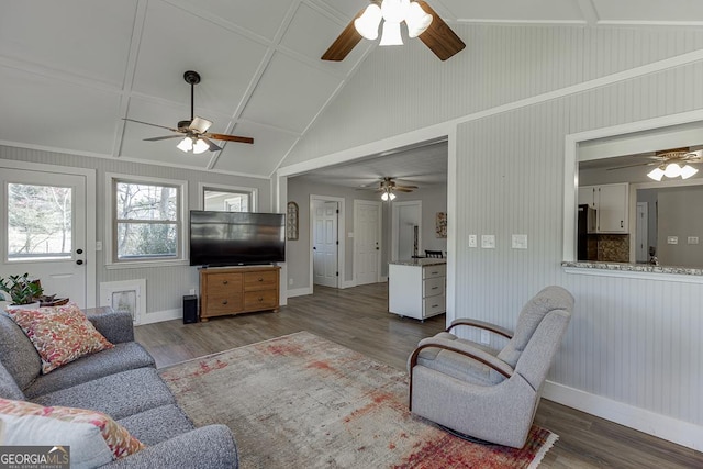 living area featuring vaulted ceiling, wood finished floors, and baseboards